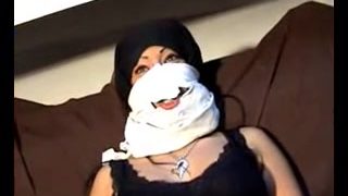 Masked Arabic lady plays with a big black dildo on tape